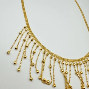 Minimalist multi-layer gold tassel necklace with faceted beads and shiny metal fringe
