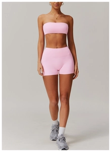 Detail of pink yoga set showing high-waist shorts and sports bra on a model