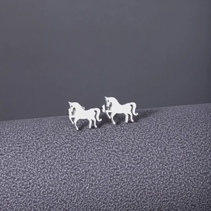 Detailed view of silver horse-shaped stud earrings with cutout design on textured background