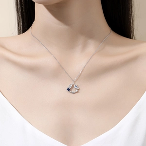 S925 sterling silver moon and star necklace with blue zircon stones on a female model