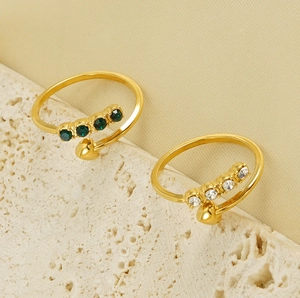 Detail of 18K gold stainless steel open rings with green and white zircon heart accents