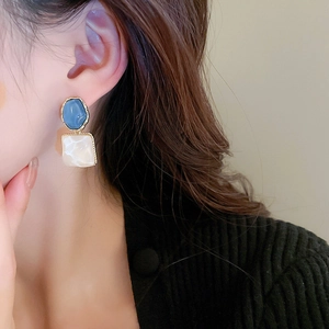 French retro blue and cream geometric resin earrings shown on model with gold trim