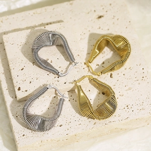 Détail de créoles torsadées en acier inoxydable plaqué or 18 carats et argent