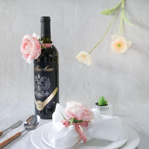 Pink heart napkin ring on a dining table with a wine bottle and roses for party decor