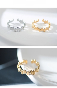 Detail of minimalist irregular geometric pill-shaped adjustable rings in gold and silver