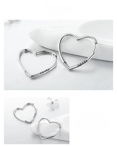 Macro shot of S925 sterling silver heart hoop earrings with LOVED engraving detail