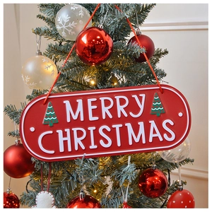 Close-up of red Merry Christmas metal sign hanging on a decorated Christmas tree