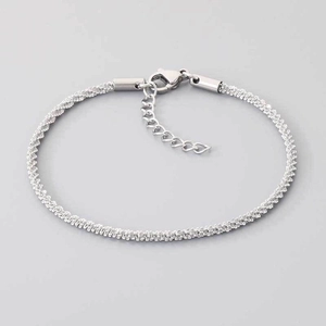 Vue détaillée du bracelet en chaîne torsadée argentée avec fermoir mousqueton et cœur
