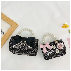 Detail of tweed mini purses with pearl handles featuring bows and rhinestone love charms