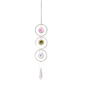 Detail of crystal suncatcher with golden sun face and faceted prisms on white background