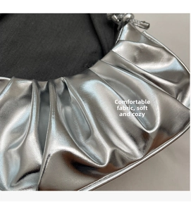 Macro shot of silver metallic pleated fabric texture and fine stitching on the cloud bag