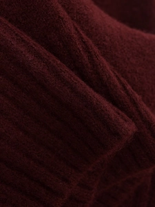 Detailed macro view of dark burgundy ribbed knit fabric showing soft wool blend texture