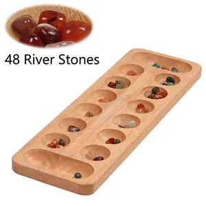 Close-up of wooden Mancala board set with 48 colorful natural rain flower stone pieces