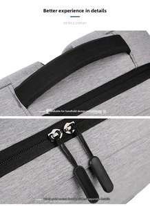 Detail of the gray laptop backpack featuring dual metal zippers and a reinforced handle