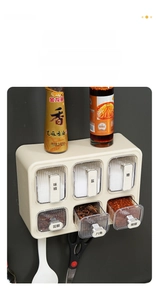 Detail of wall-mounted kitchen spice rack with six labeled transparent drawers for storage