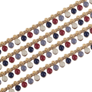 Close-up of golden enamel bead chain with red, blue and grey charms for DIY jewelry making