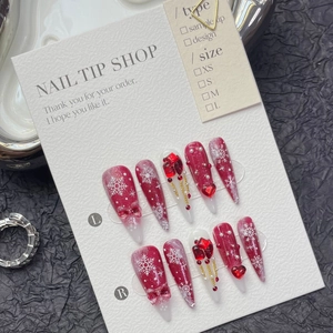 Christmas snowflake press-on nails with red bows, pearls and crystals on a stiletto shape