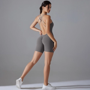 Detail of cross back straps and ruched butt lifting design on dark grey yoga bodysuit