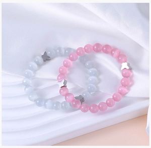 Close-up of pink and blue cat eye stone bead bracelets with silver butterfly charms