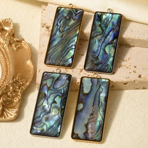Macro view of rectangular abalone shell pendants with gold and silver stainless steel frames
