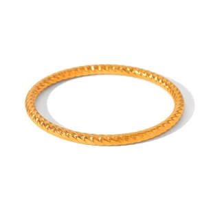 Macro detail of gold stainless steel twisted rope texture bangle with a metallic finish