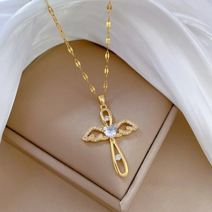 Gold angel wing cross necklace with heart-shaped zircon and textured feather details