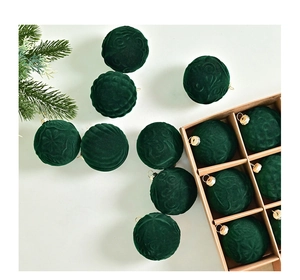 Detail of dark green velvet Christmas balls with embossed patterns and metal loops