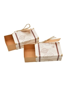 Detailed macro view of vintage kraft paper mini suitcase candy boxes with twine bows