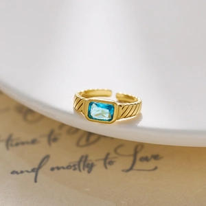 Macro detail of a vintage 18k gold-plated ring with a rectangular blue crystal gem