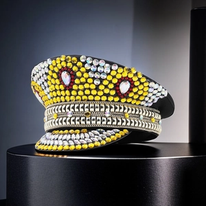 Macro shot of wedding captain hat featuring yellow and red rhinestones and metal chains