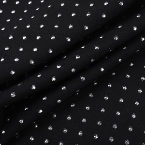 Detailed macro view of black fabric with sparkling silver sequins and polka dot patterns