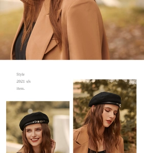 Detail of a vintage black beret featuring a metal star ornament and stylish street look