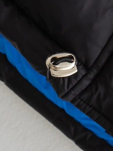 Détail des cordons de serrage argentés et coutures contrastées sur la veste sans manches