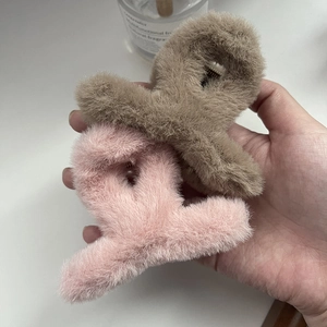 Dettaglio di mollettoni in morbido peluche rosa e marrone per acconciature autunnali