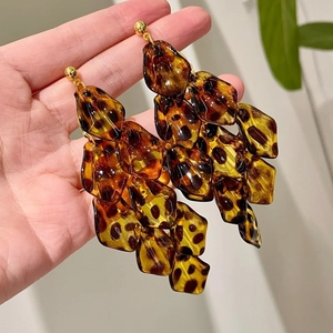 Detail of tortoiseshell acrylic petal earrings featuring a vintage layered drop design
