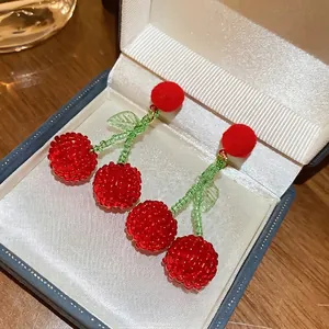 Exquisite cherry beaded drop earrings with red pom-poms and green leaf accents