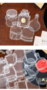 Macro shot of clear PET journal stickers featuring white ink bottle and vase outlines