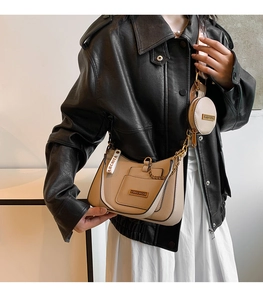 Chic beige crossbody bag with gold chain and matching coin purse shown on a model