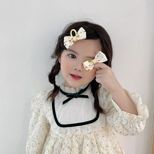 Pair of sweet fabric polka dot bow hair clips for girls on a minimalist background