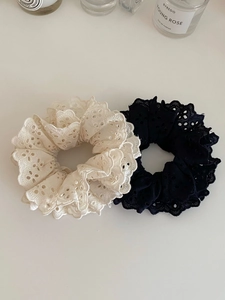 Détail de chouchous en dentelle double épaisseur noire et blanche avec broderie ajourée