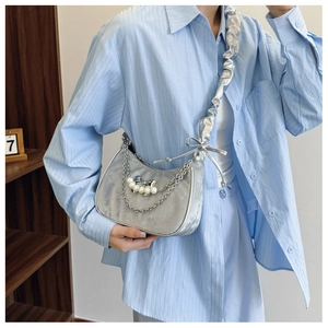 Detail of silver pleated shoulder bag with pearl bow charm and double metal chain