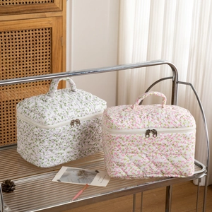 Quilted floral makeup bag with top handle and double zipper for travel storage