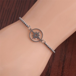 Detail view of adjustable silver compass star charm bracelet on model wrist