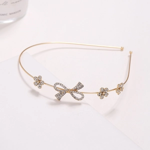 Close-up of golden headband with sparkling rhinestone flower and butterfly details