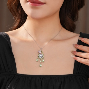Dettaglio di una collana con fiori in zircone e nappe a goccia d'acqua verde