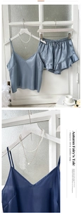 Détail d'un pyjama en satin bleu montrant la texture soie et le short à volants