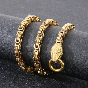 Macro detail of golden Byzantine chain featuring ornate snake head clasp for men