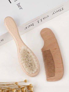 Detail of wooden baby hair brush with soft bristles and a matching wood comb set