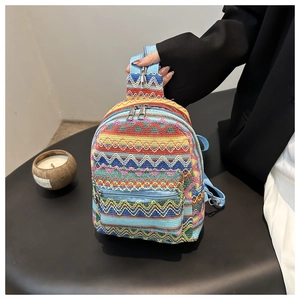 Detail of colorful woven bohemian mini backpack with zigzag geometric patterns and metal zip