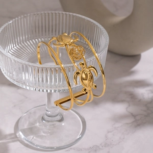 Dettaglio del bracciale rigido a tartaruga placcato oro 18K appeso a un bicchiere